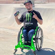 aaron sitting in wheelchair holding a monster energy drink wearing a monster energy shirt